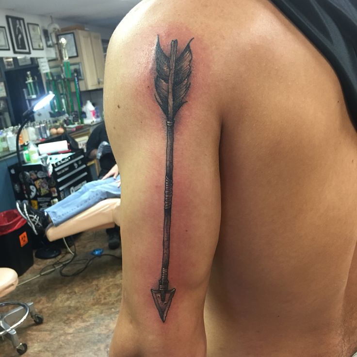 a man with a tattoo on his back holding an arrow