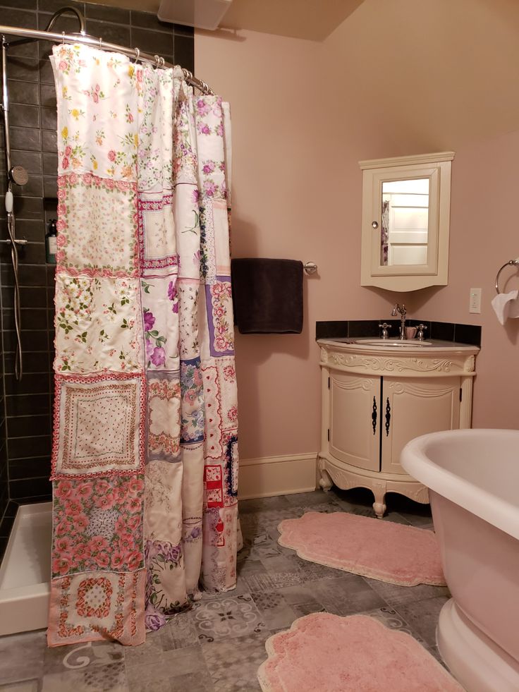 a bath room with a sink and a bath tub next to a shower curtain on the wall