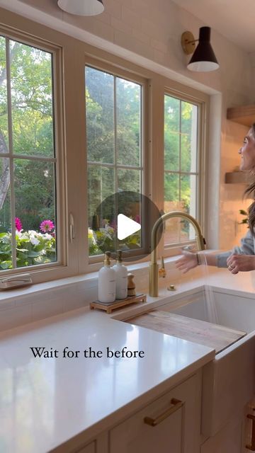 a woman standing in front of a kitchen sink next to a window with the words wait for the before written on it