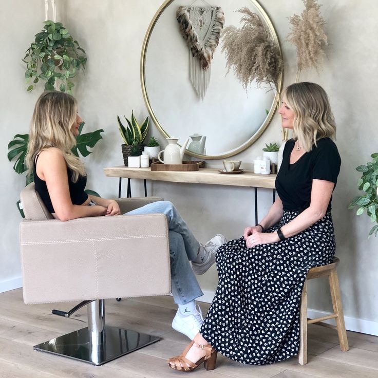 two women sitting in chairs talking to each other