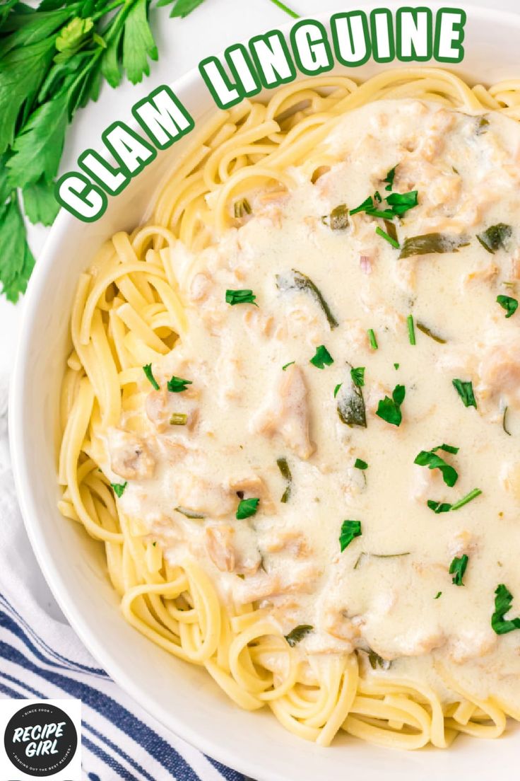 a white bowl filled with pasta covered in cream sauce and garnished with parsley