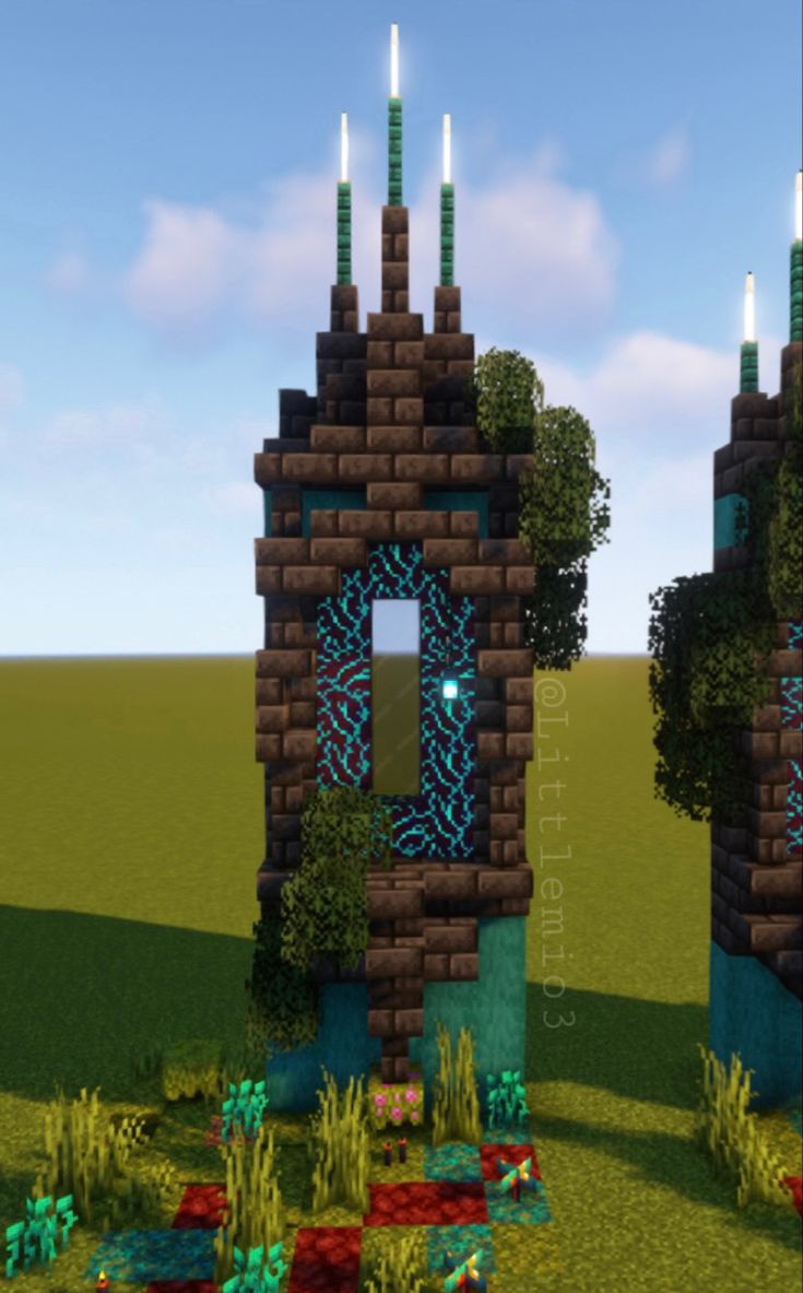 two small towers with candles on them in the middle of some grass and bushes,