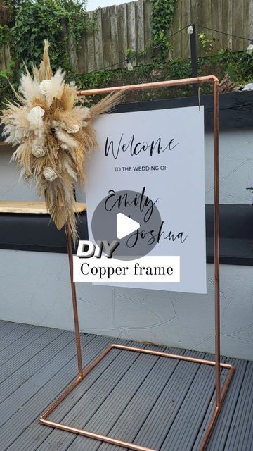 a welcome sign on a metal stand with a flower in the center and an inscription that reads, welcome to the treasures of curly bob's copper frame