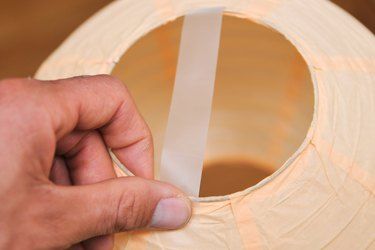 a person holding a piece of paper near a round object that is cut in half