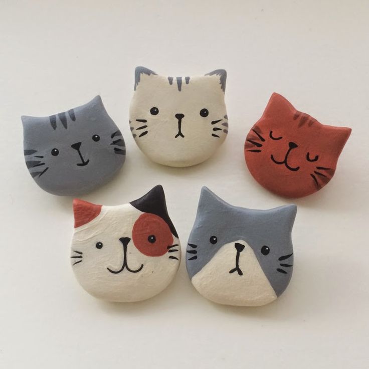 four cat magnets are shown on a white surface