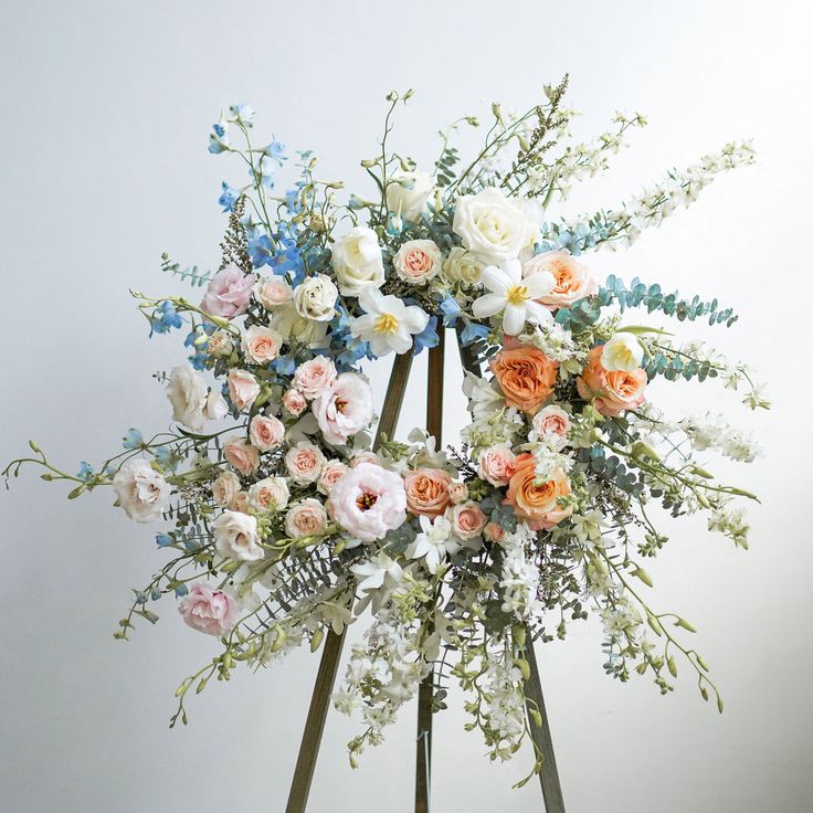 an arrangement of flowers is arranged on a stand