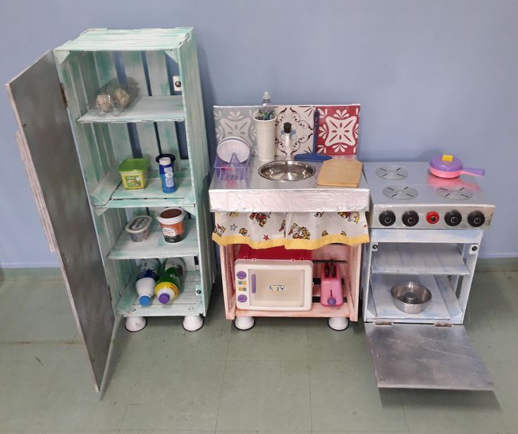 two play kitchen sets are shown next to each other on the floor in front of a blue wall