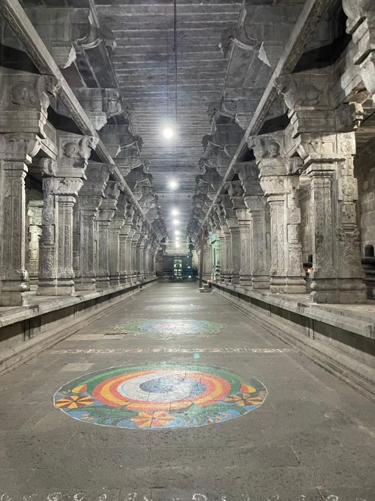 the inside of an old building with painted floors and pillars on either side of it