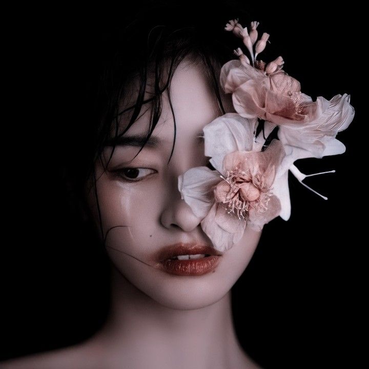 an image of a woman with flowers in her hair and make - up on her face