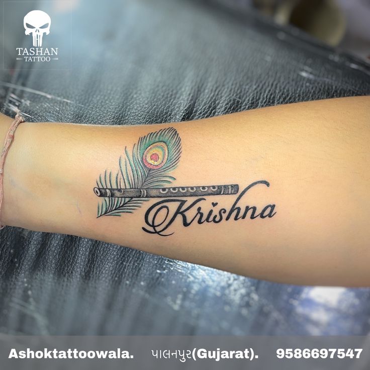 a woman's arm with a tattoo that reads kishna and a feather on it