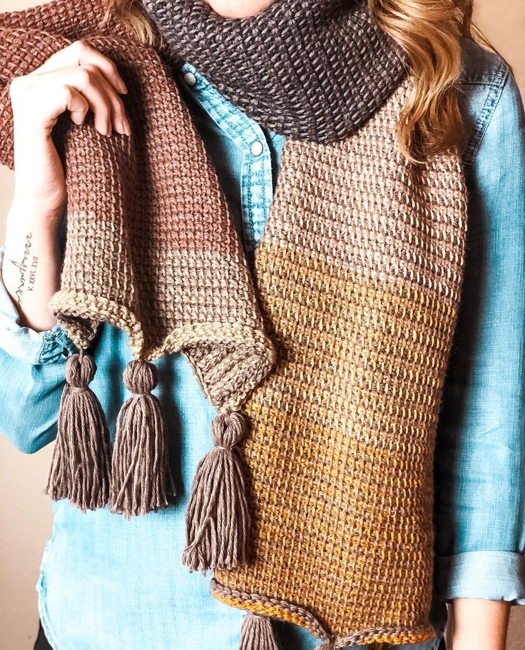 a woman wearing a scarf with tassels on it