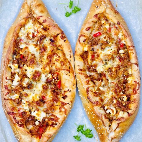 two pizzas sitting on top of a white plate covered in cheese and toppings