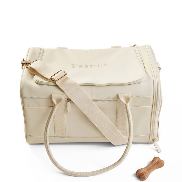 a white purse with a dog bone on the side and a small bag next to it