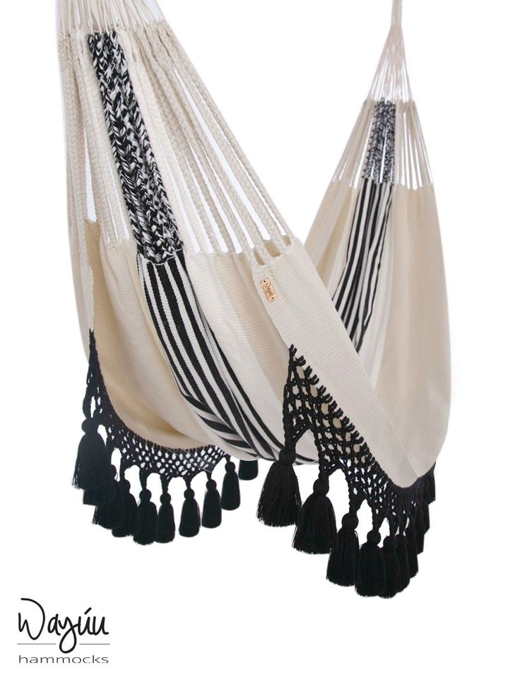 a white and black hammock with tassels