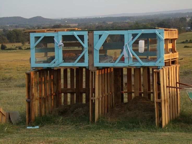 a wooden structure in the middle of a field