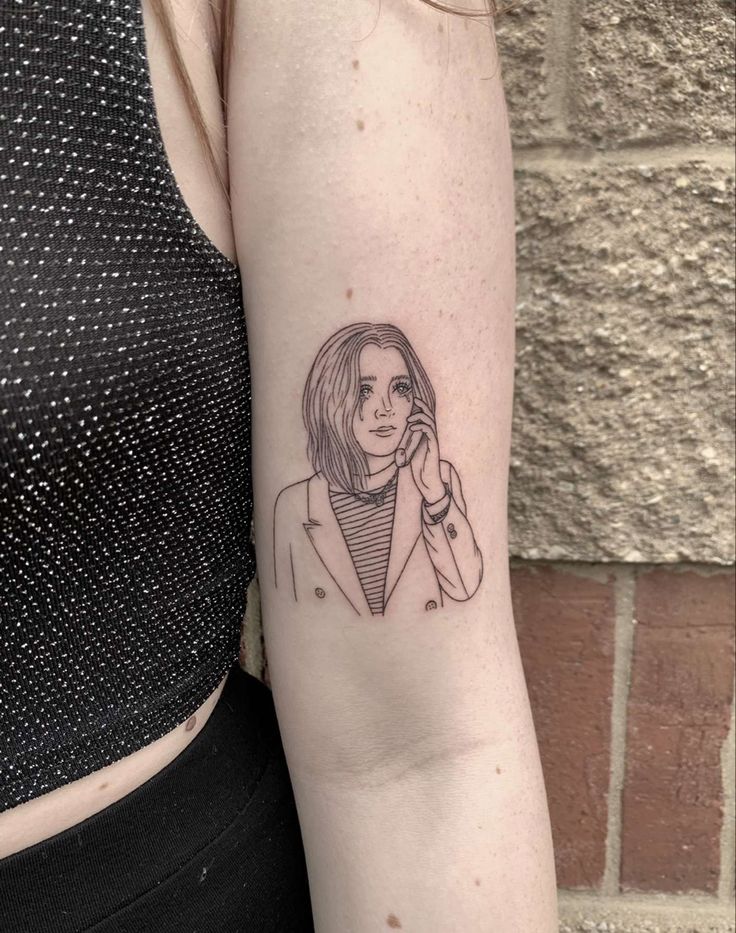 a woman's arm with a small tattoo of a girl talking on the phone