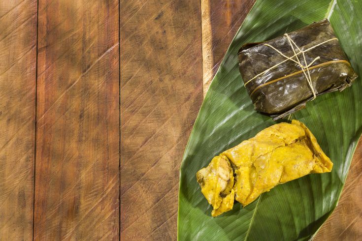 a piece of food on top of a green leaf next to a wooden wall and floor