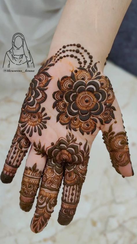 the hand is decorated with henna and flowers