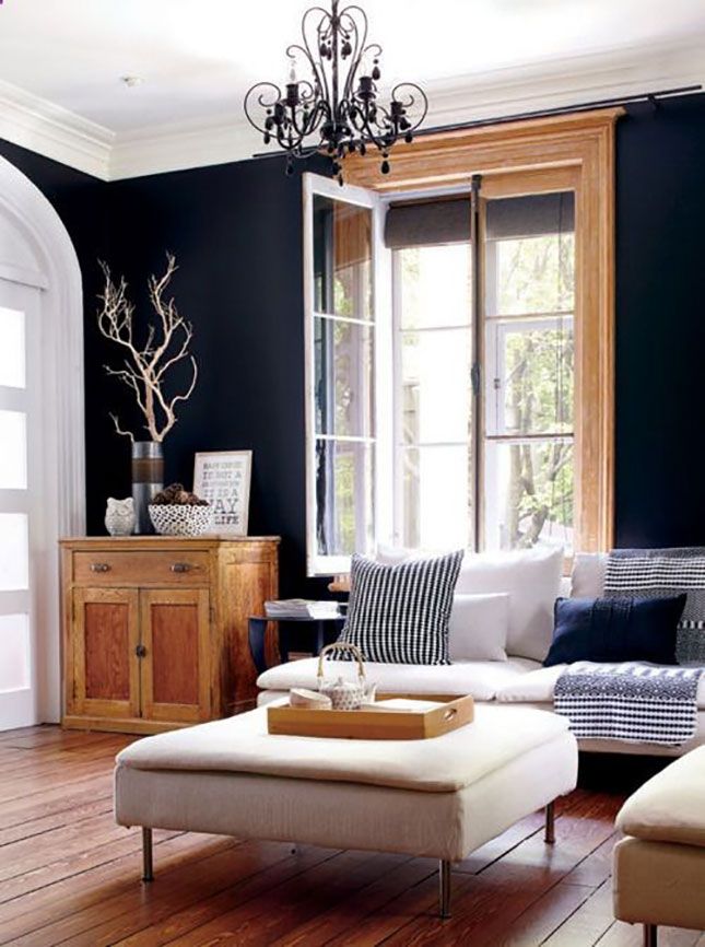 a living room filled with furniture and a chandelier hanging from the ceiling over a wooden floor