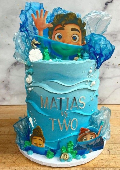 a blue cake with an image of a boy in the ocean