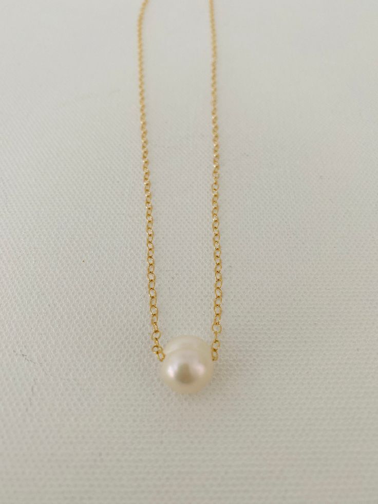 Just A Pearl! This simple yet elegant necklace is part of my Just A Pearl collection. One single pearl dangles from a delicate gold necklace. It measures 16 inches and length and can be adjusted to 15 inches for choker length. Gold Single Strand Dainty Pearl Necklace, Classic Pearl White Chain Necklace With Pearl Pendant, Classic Pearl Pendant Chain Necklace, Classic Gold Charm Necklace With Pearl Drop, Dainty Charm Necklace With Pearl Chain And Round Pendant, Classic Pearl Necklace With Delicate Chain, Classic Gold Charm Necklace With Pearl Chain, Classic Gold Pearl Chain Charm Necklaces, Simple Pearl Chain Necklace