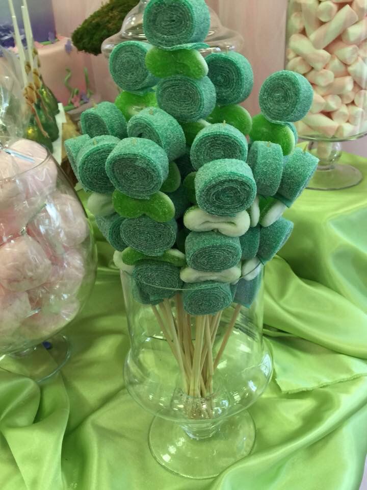 a vase filled with green and white marshmallows on top of a table