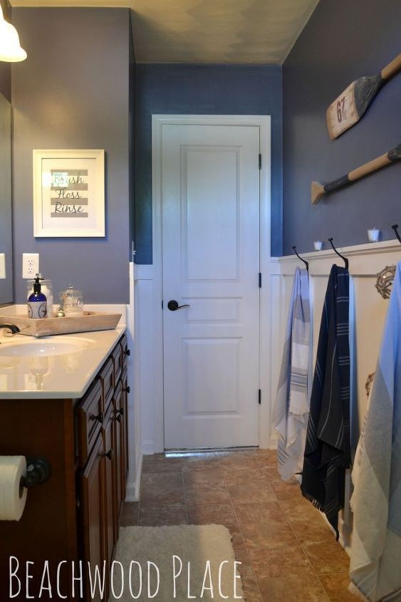 a bathroom with blue walls and white doors is pictured in this image, there are towels hanging on the rack next to the door