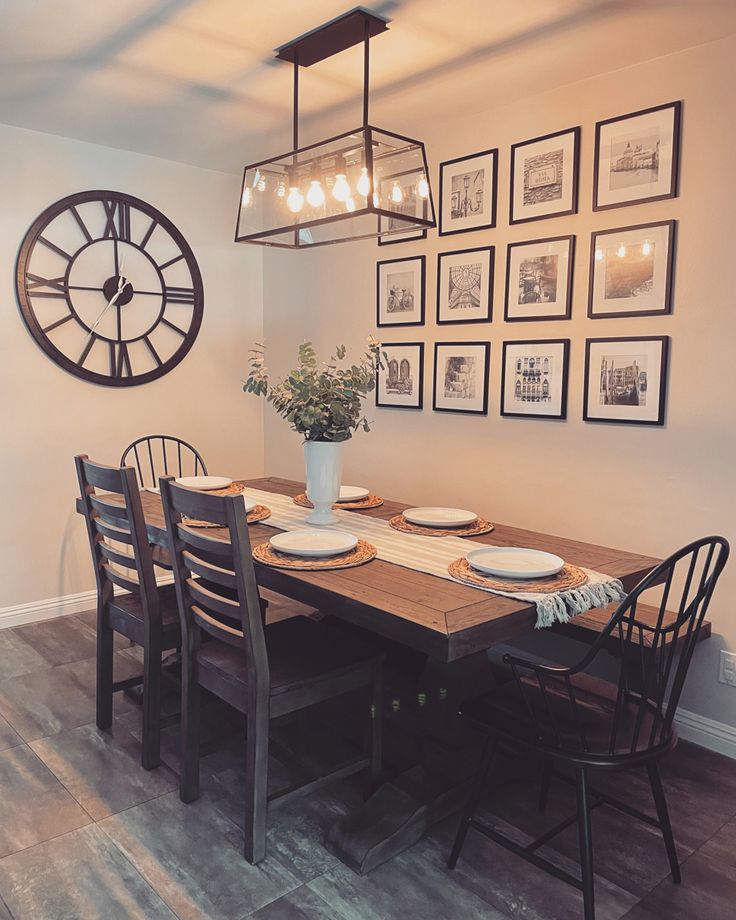 a dinning room table with chairs and pictures on the wall in front of it