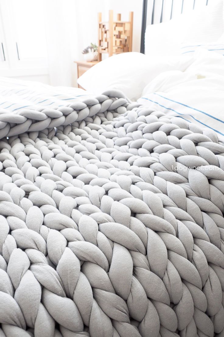 a bed with a white comforter on top of it