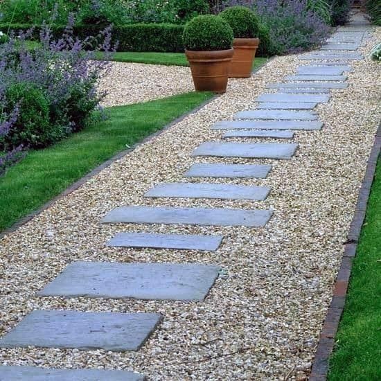 a stone path in the middle of a garden