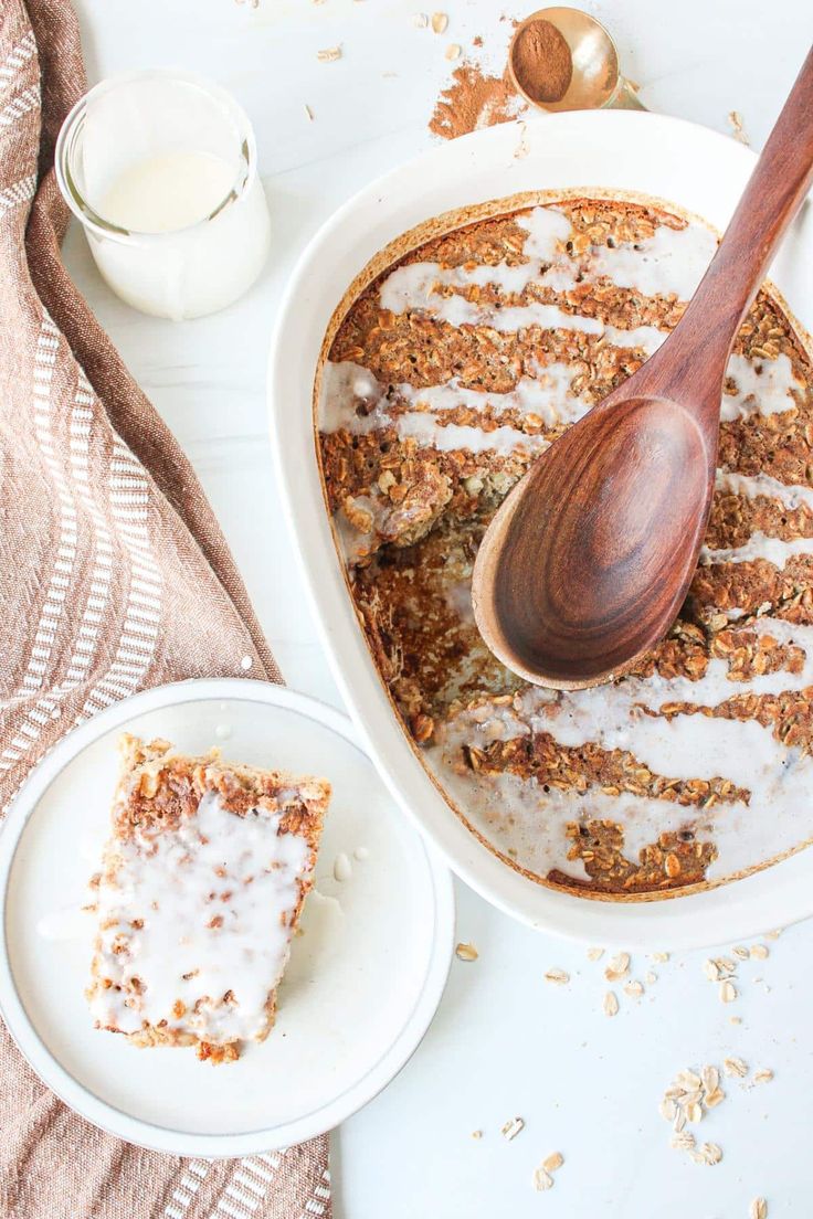 a wooden spoon sitting on top of a white plate next to a bowl of cereal