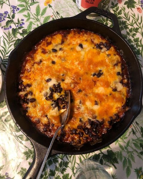 a skillet filled with cheese and black beans