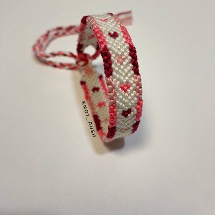 a red and white bracelet with hearts on it