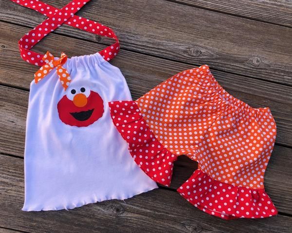 two children's clothing sitting on top of a wooden table