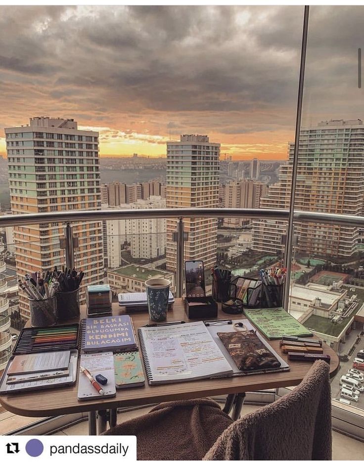 an office desk on top of a building with a view of the city in the distance