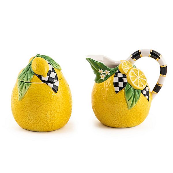 two yellow lemons with black and white designs on them, one has a bow