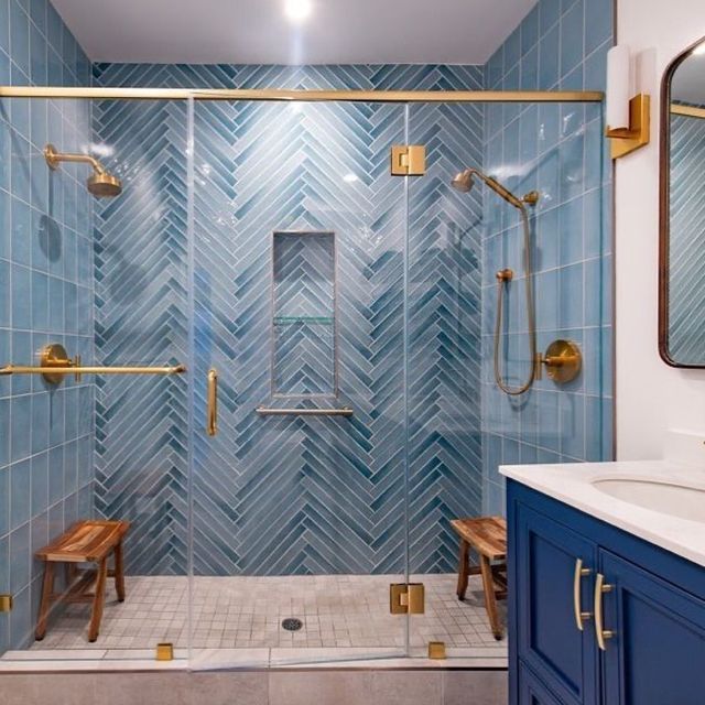 a bathroom with blue and gold accents, including a walk - in shower next to a sink