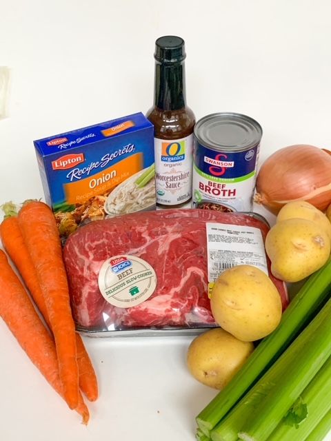 some carrots, celery, potatoes and meat on a white counter top