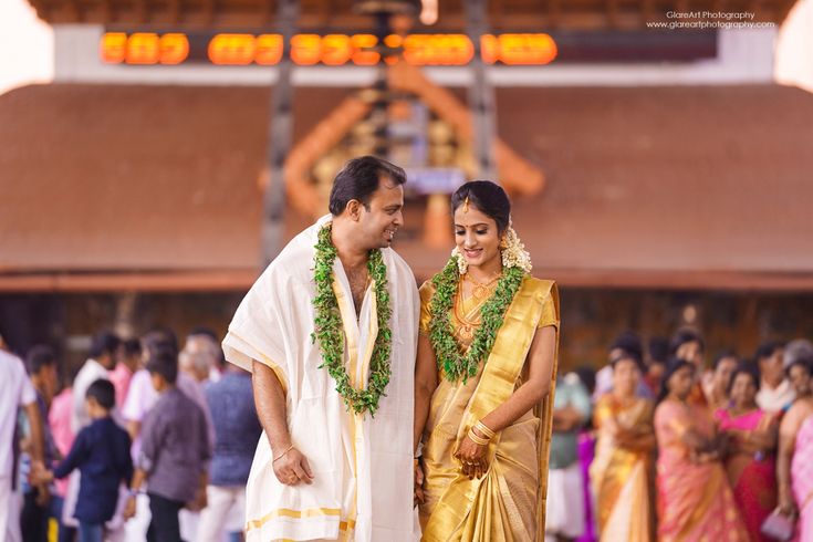 a man and woman standing next to each other in front of a group of people