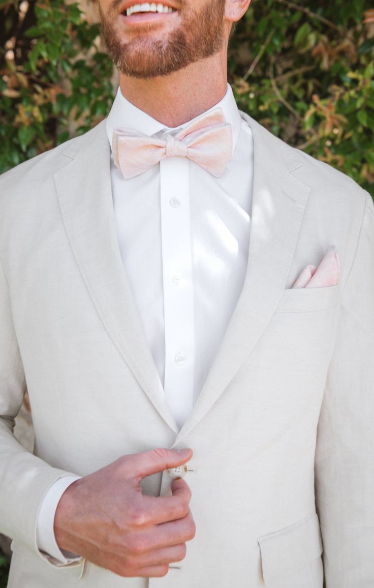 a man wearing a white suit and bow tie