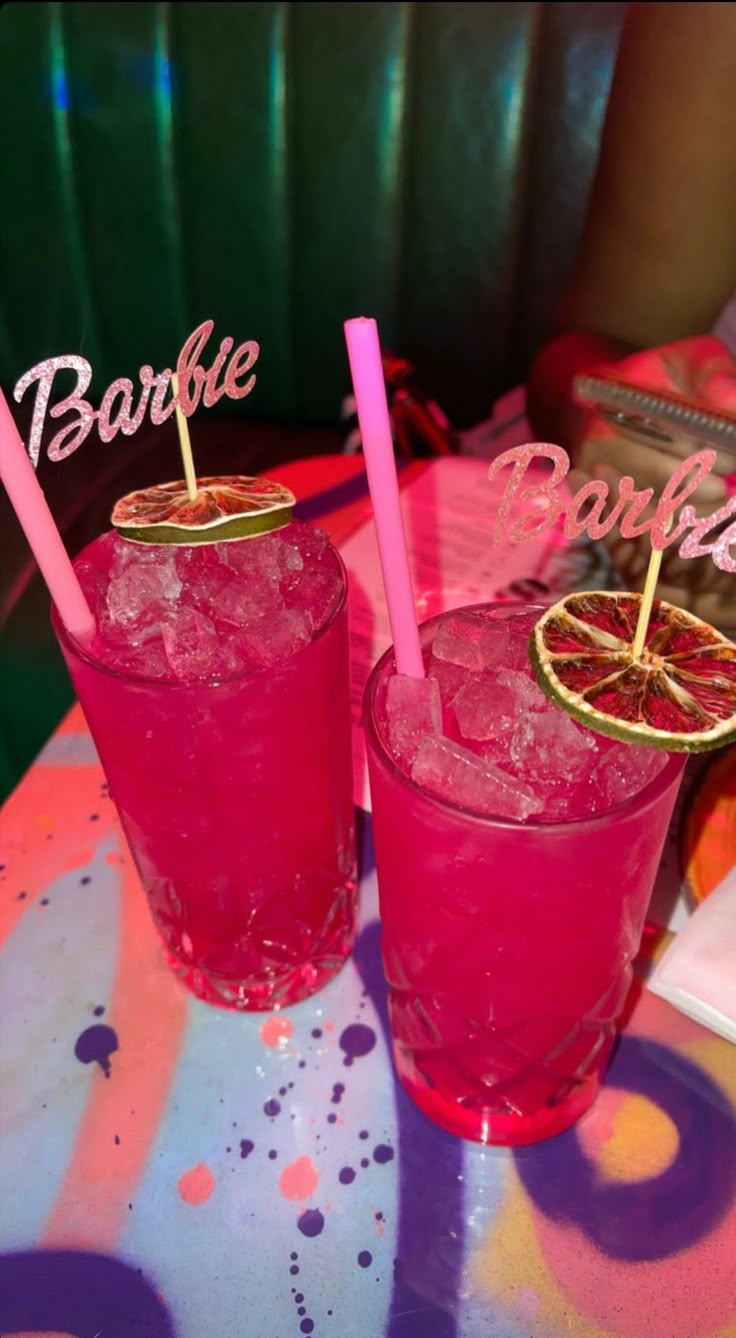 two pink cocktails sitting on top of a table