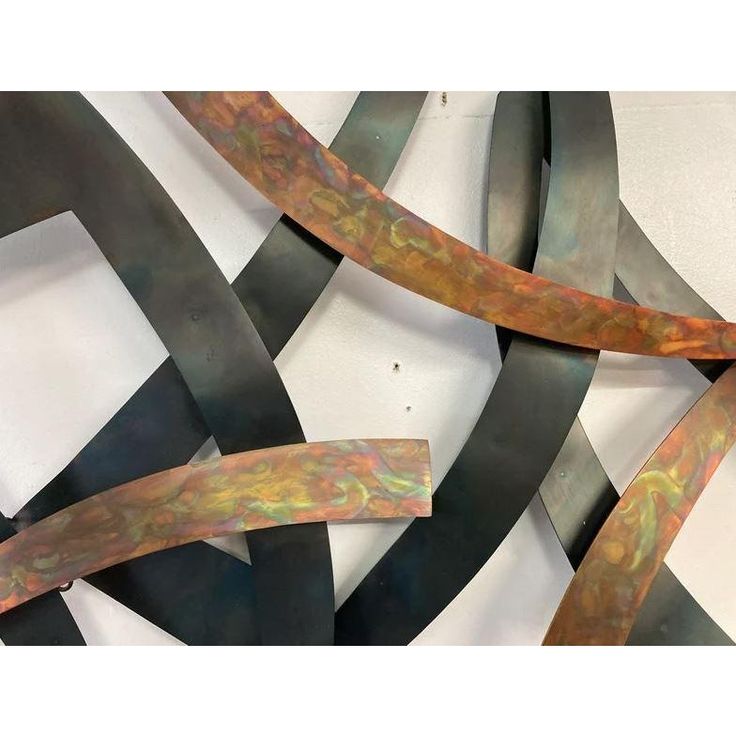 an abstract metal sculpture with wavy lines in the center and curved shapes at the bottom