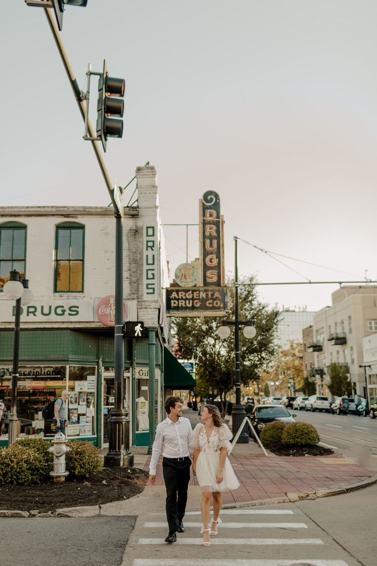 a man and woman walking across a cross walk