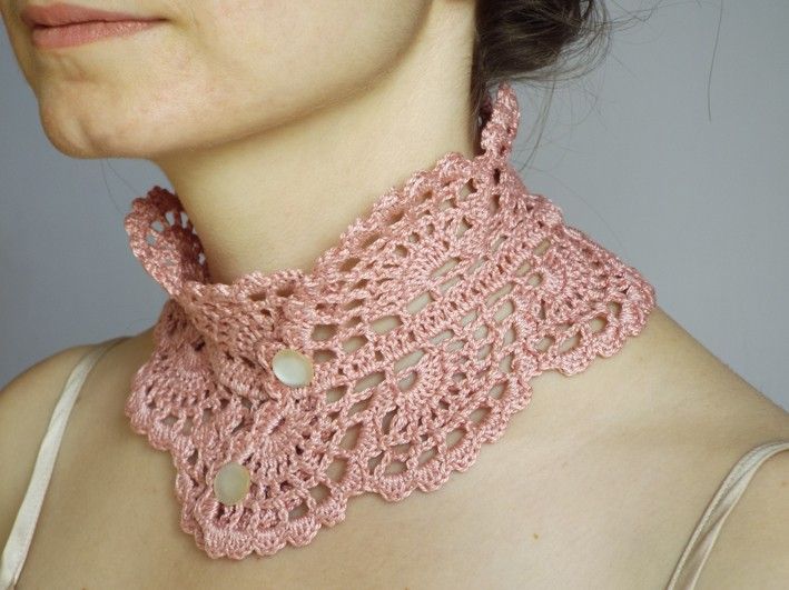 a woman wearing a pink crocheted neck scarf with holes on the collar and sides