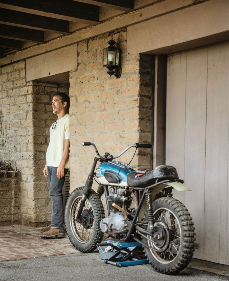 a man standing next to a parked motorcycle