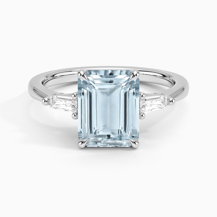 an aqua blue topazte ring with diamonds on the sides and side stones around it