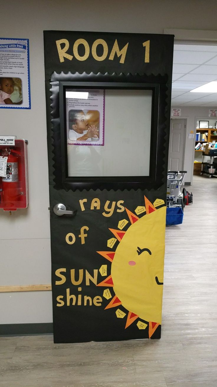 a classroom door decorated to look like the sun shines in the room with pictures on it