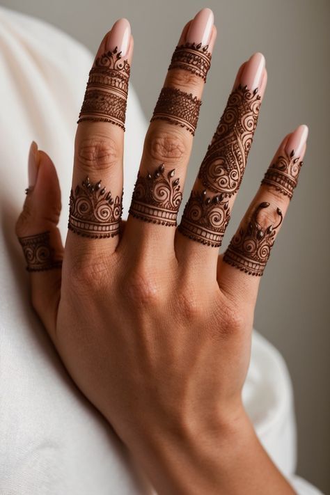 a woman's hand with hennap tattoos on her fingers and two rings