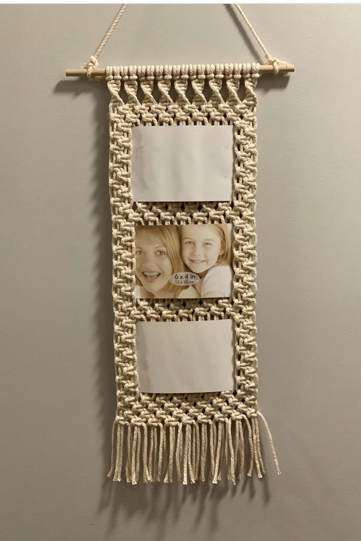 a wall hanging with three pictures and two tassels attached to the side of it