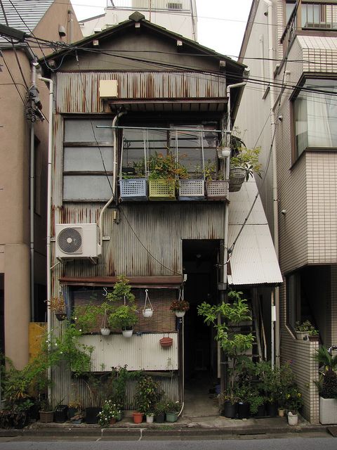 an apartment building with plants growing out of the windows